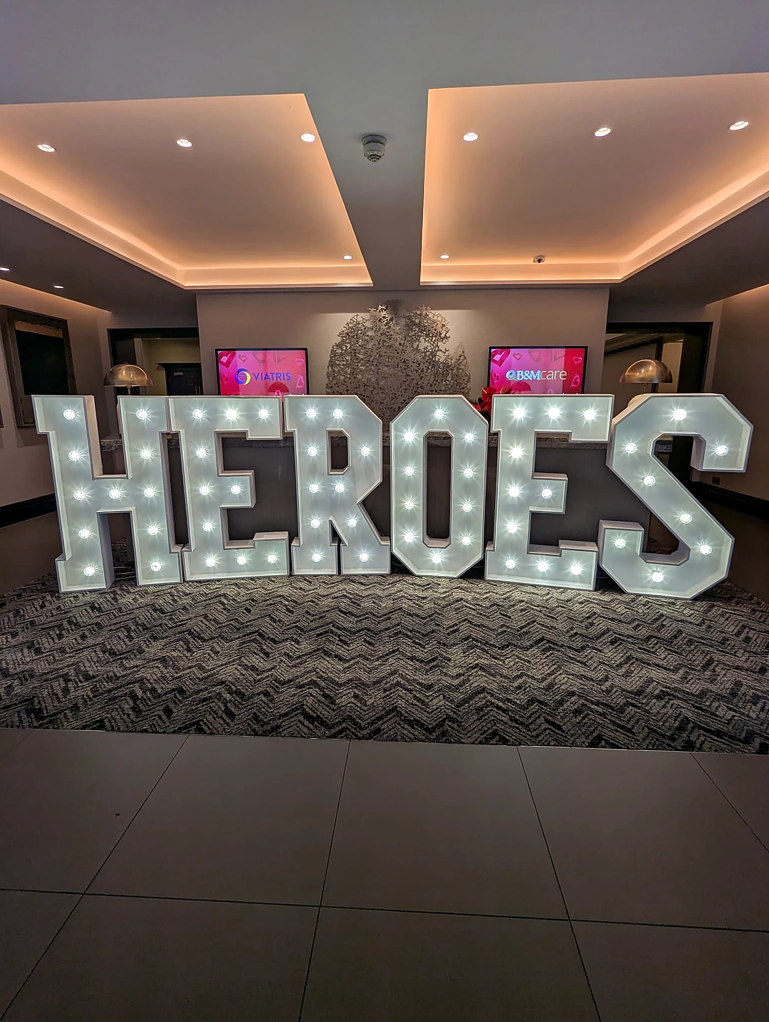 HEROES illuminated letters at a corporate event